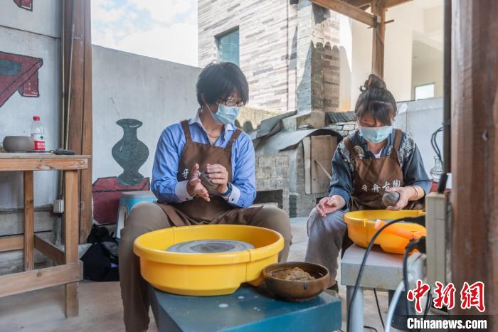 圖為日本駐重慶總領(lǐng)事高田真里體驗(yàn)平塘牙舟陶?!√普?攝 圖為日本駐重慶總領(lǐng)事高田真里體驗(yàn)平塘牙舟陶?!√普?攝