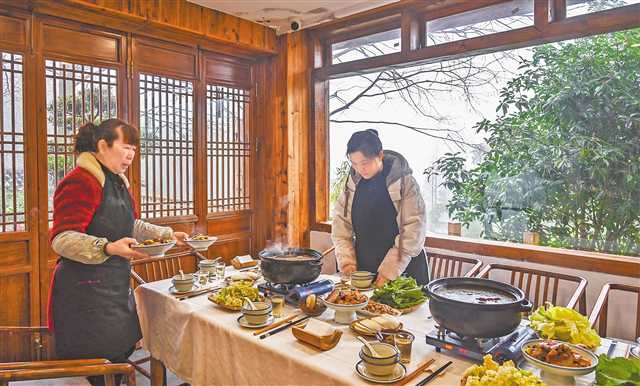一月十五日,縉云村,“山之語”民宿老板周紅(右)正在為客人準備美食。