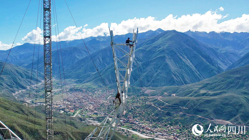 在四川省甘孜州巴塘縣至瀾滄江500千伏線路施工現(xiàn)場，電力工人正在高空進(jìn)行鐵塔組立作業(yè)。劉洋攝