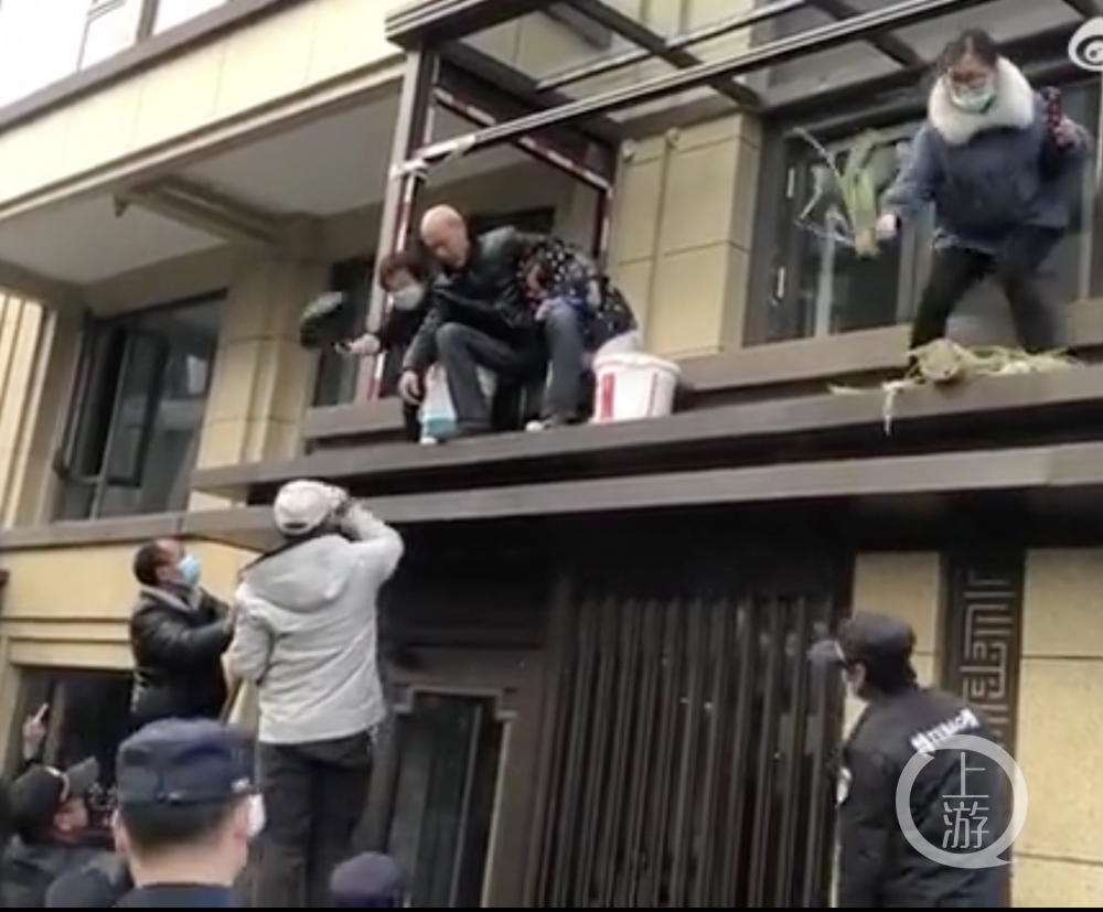 ▲在執(zhí)法過程中，業(yè)主用平底鍋和盆栽砸向執(zhí)法人員。圖片來源/視頻截圖