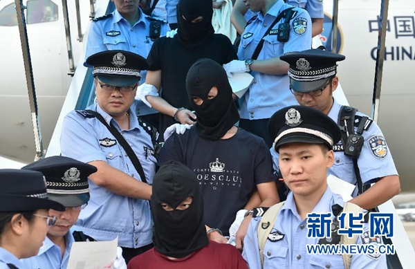 在廣州白云國際機(jī)場，電信詐騙犯罪嫌疑人在公安民警押解下走下飛機(jī)（9月2日攝）。